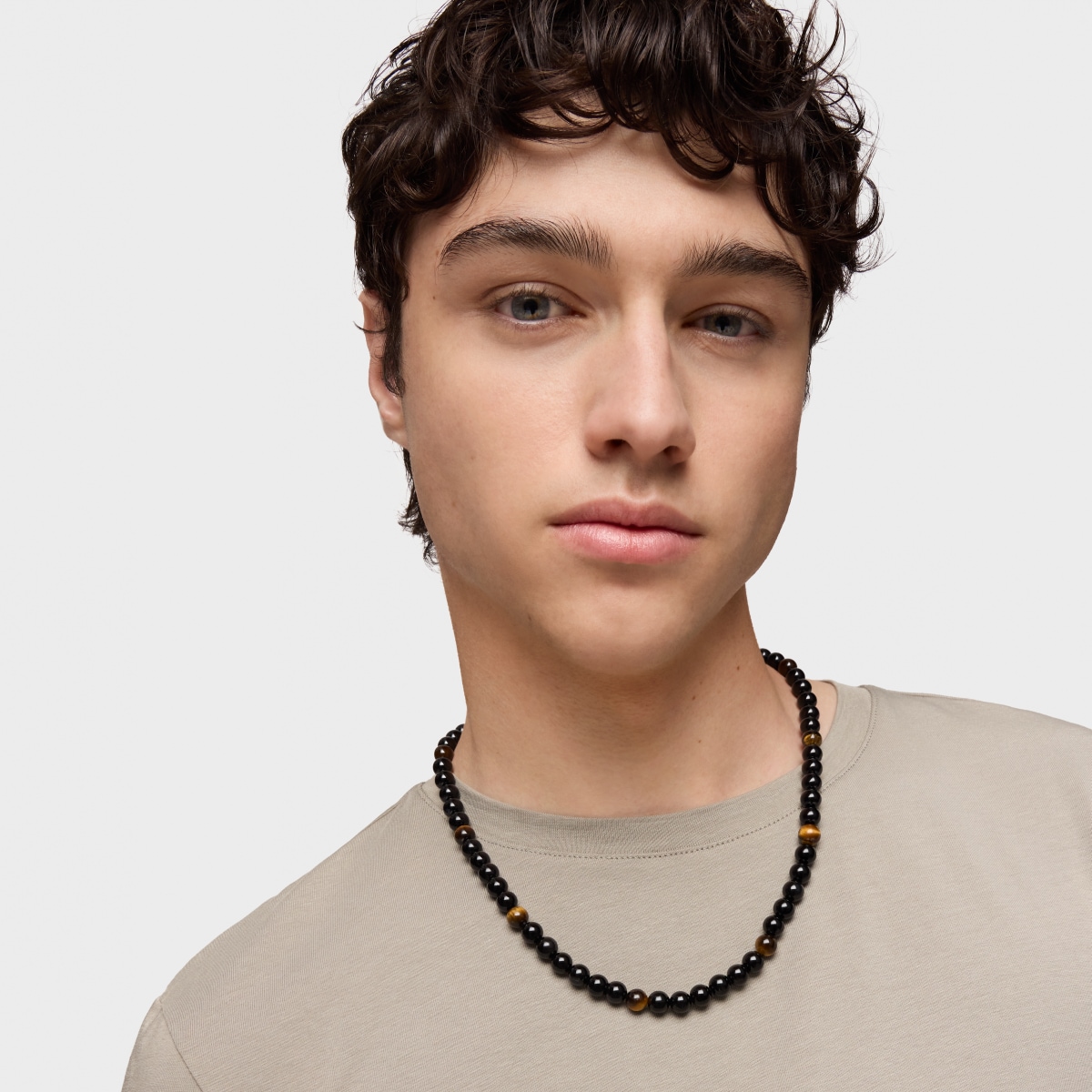 Silver necklace with onyx, tiger’s eye, and Hold Man rings