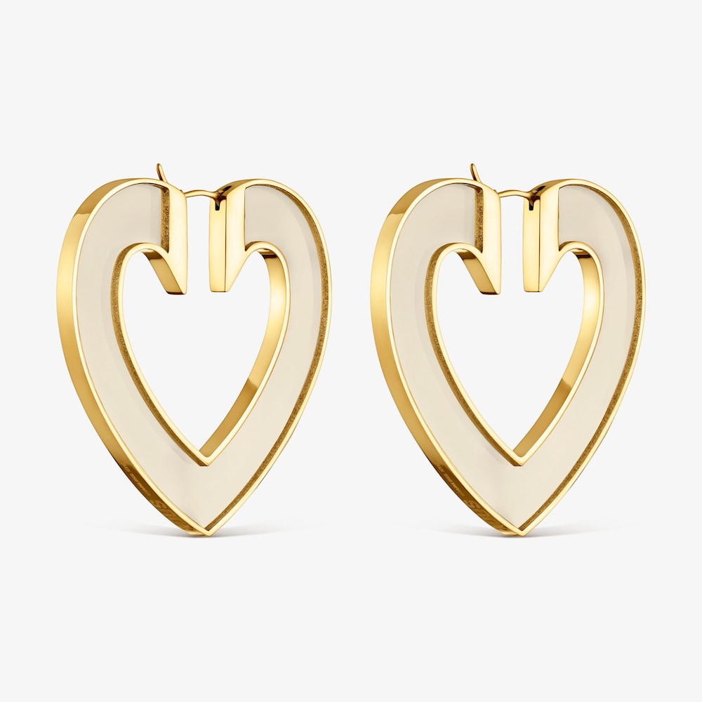 N&aacute;u&scaron;nice ve tvaru srdce o&nbsp;velikosti 50&nbsp;mm z&nbsp;oceli ve zlat&eacute; barvě a&nbsp;b&iacute;l&eacute; pryskyřice TOUS Galaxy