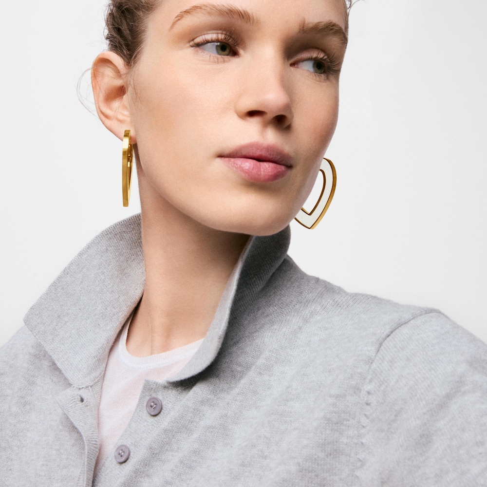 N&aacute;u&scaron;nice ve tvaru srdce o&nbsp;velikosti 50&nbsp;mm z&nbsp;oceli ve zlat&eacute; barvě a&nbsp;b&iacute;l&eacute; pryskyřice TOUS Galaxy