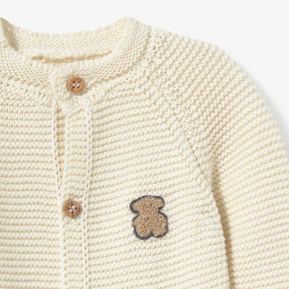 Newborn baby romper in natural-coloured knit
