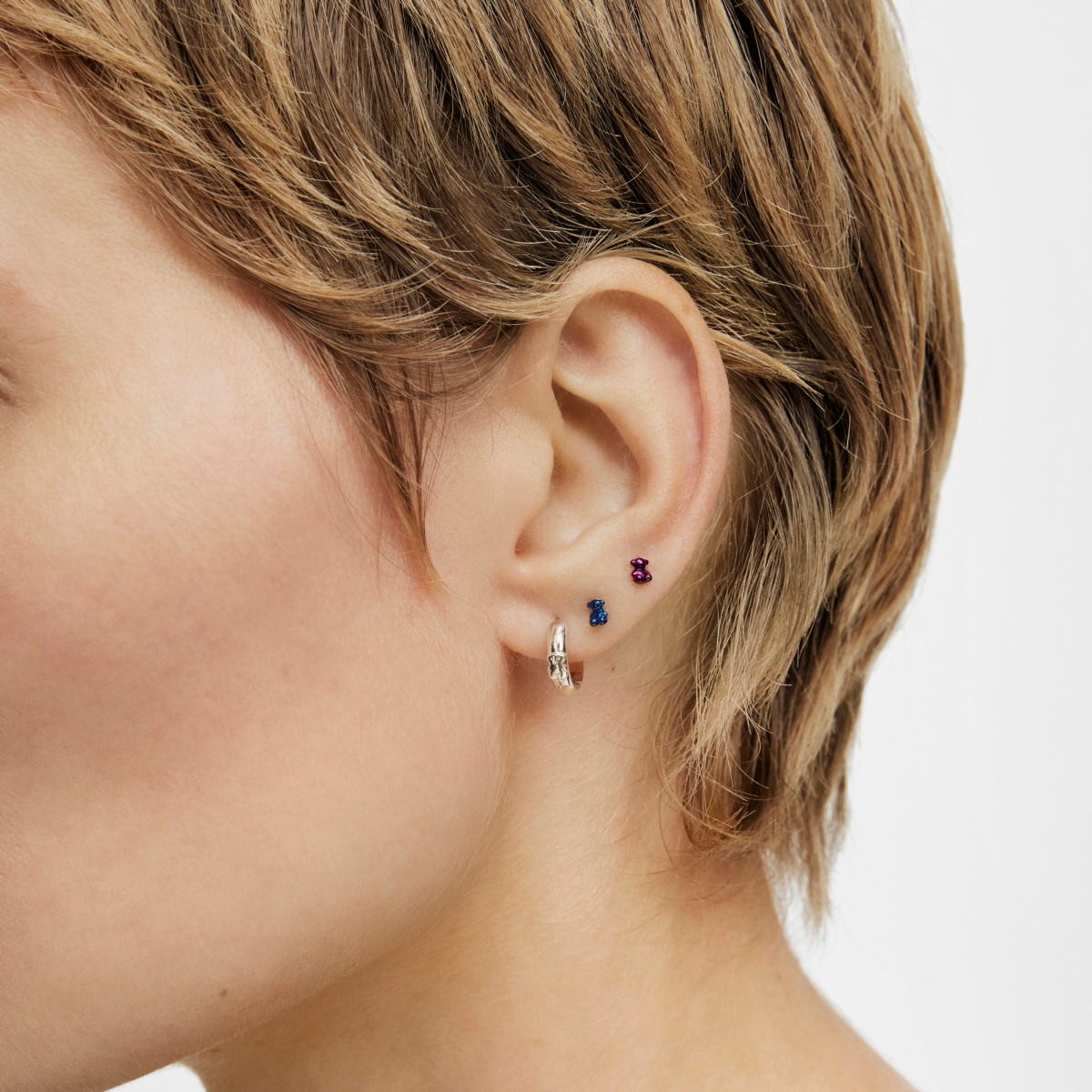Pack of Bold Bear Ear piercings in lilac- and green-colored IP steel